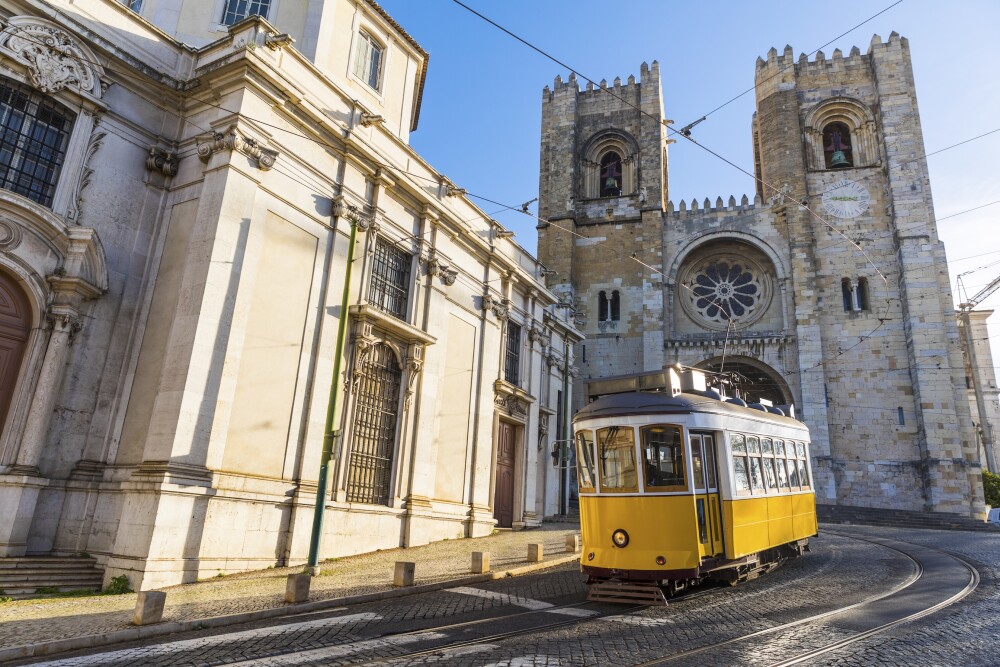 Portugal Lisbon typical yellow tram in front of the Cathedral 970179030